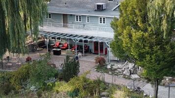 A house with a covered patio area, surrounded by greenery and trees.