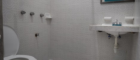 A bathroom with a toilet, a sink, and a shower.