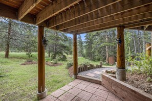 Guests can enjoy a serene outdoor space with a covered area and a wooden deck overlooking the surrounding landscape.