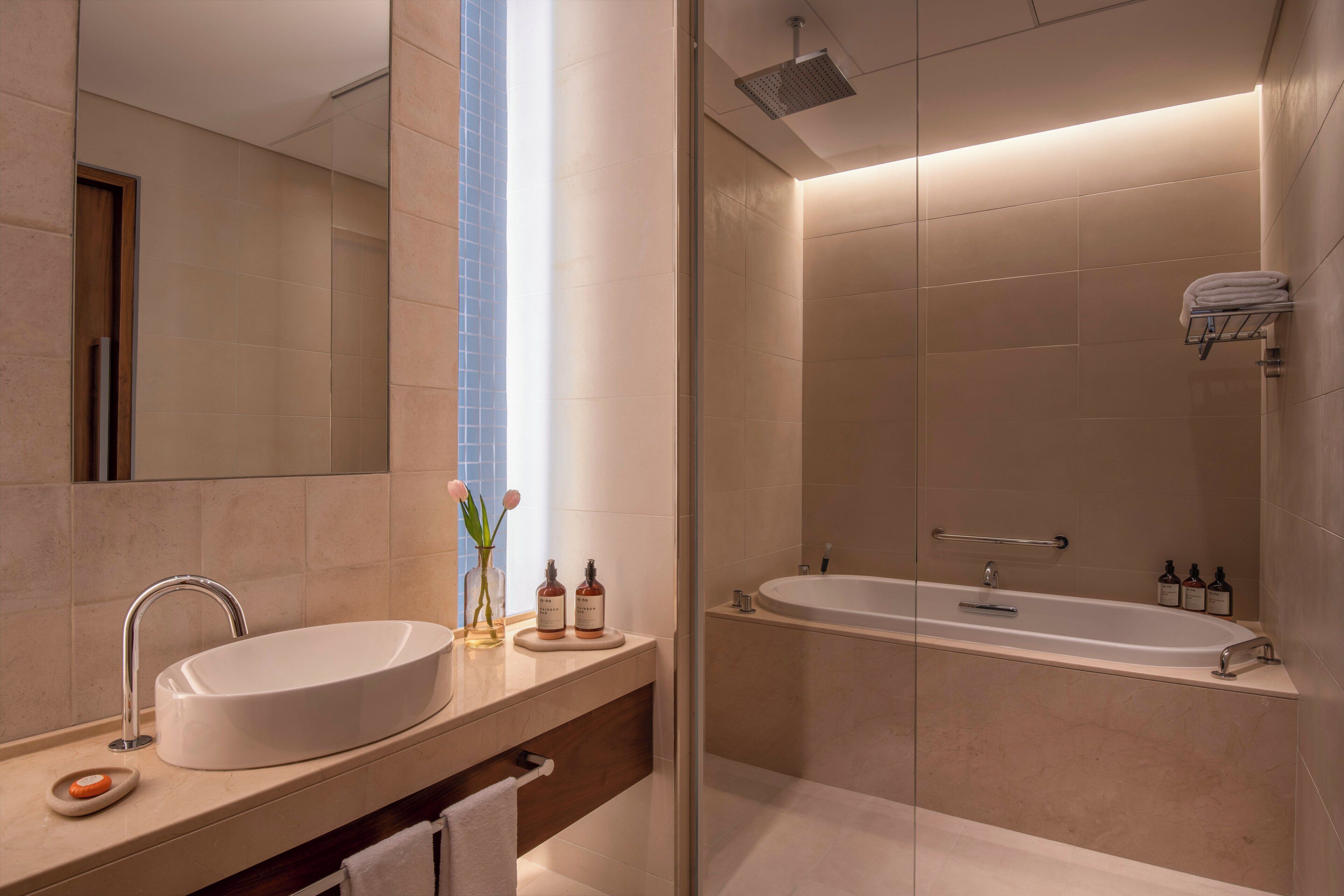 Une salle de bain moderne avec un lavabo, un miroir et un espace douche.