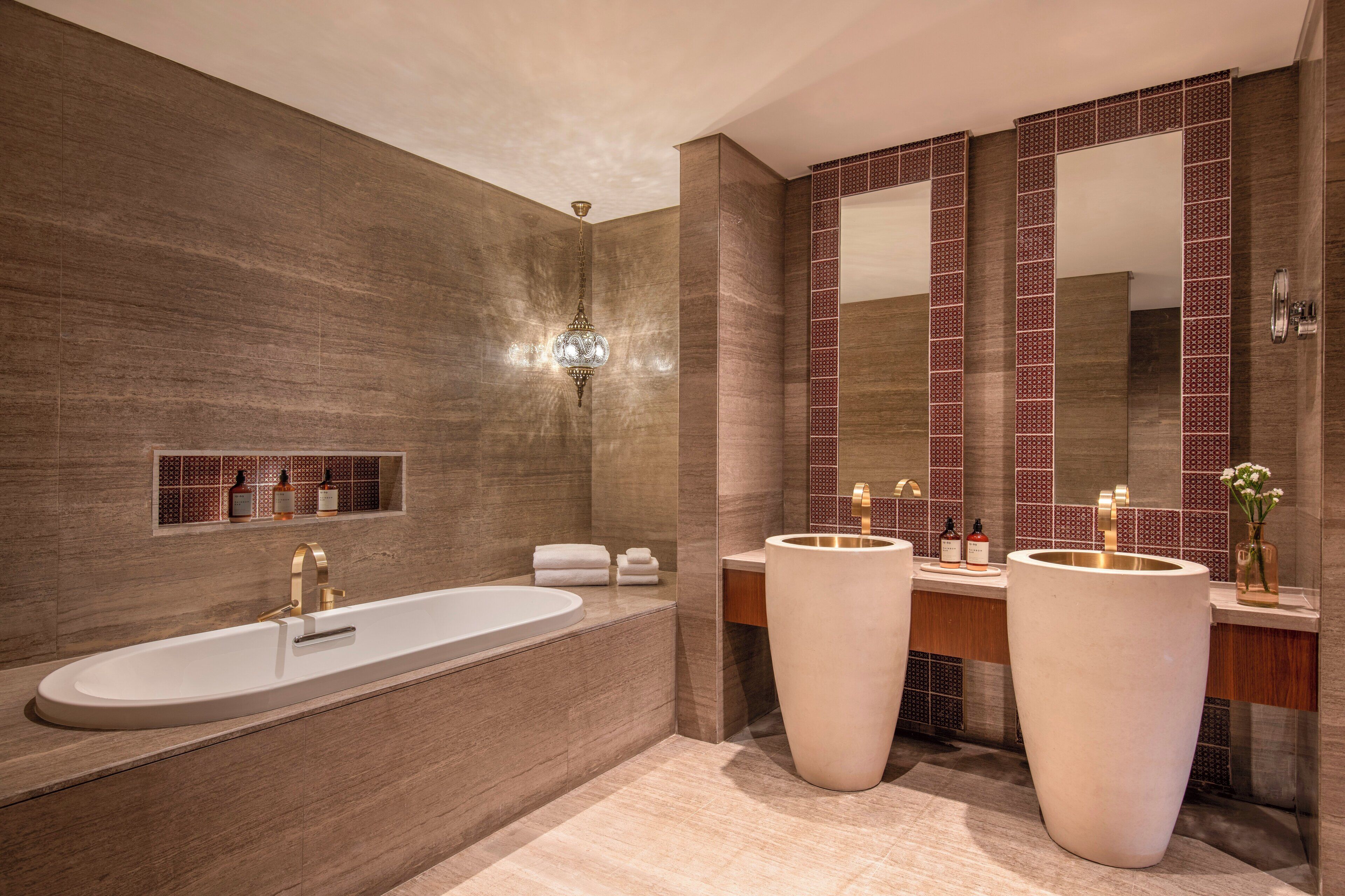 Un baño moderno con una bañera grande, dos lavamanos y un espejo amplio.