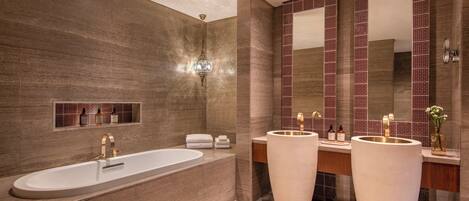 Un baño moderno con una bañera grande, dos lavamanos y un espejo amplio.
