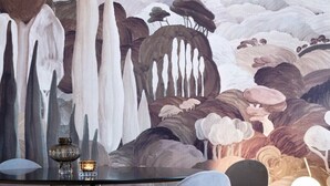 A dining area with a mural of mushrooms and trees, modern furniture, and a small table with a candle. - Notre-Dame 3* - OG IMMO (Annecy)