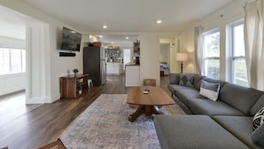 Un salón espacioso con sofá, mesa de centro y vista a la cocina.