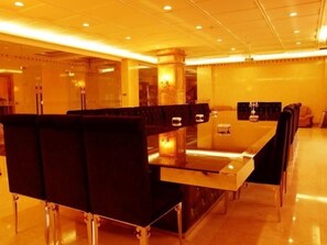 Un comedor moderno con una mesa larga y sillas tapizadas de color negro.