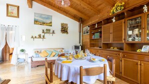 A cozy dining area with a round table set for four, surrounded by wooden chairs. - 2 bedroom lovely home in Sillano (Sillano)