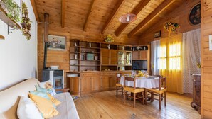 A cozy wooden cabin interior with a sofa, dining table, and various shelves and cabinets. - 2 bedroom lovely home in Sillano (Sillano)