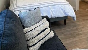 Makuuhuoneessa on sänky, yöpöytä, lamppu ja liukuovi, joka johtaa kylpyhuoneeseen.
