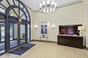 Enter a beautifully designed lobby with an arched entrance, chandelier, and reception desk.