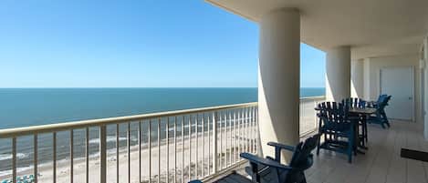 A balcony with a view of the beach and ocean.