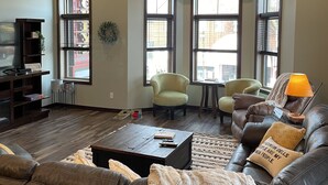A living room with a wooden ceiling, a ceiling fan, a fireplace, a sofa, a coffee table, and a TV. - Fantastic Location! Downtown Wisconsin Dells (Wisconsin Dells)