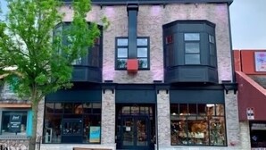 A two-story building with a brick facade and large windows. There are benches in front of the building. - Fantastic Location! Downtown Wisconsin Dells (Wisconsin Dells)
