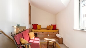 A compact living space with a sofa, a small table, and a wooden cabinet. - Nazaré Boutique Apartment II (Nazaré)