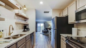 Una cocina moderna con electrodomésticos de acero inoxidable, armarios de madera y una isla central.