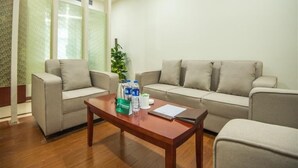 A room with two sofas, a wooden coffee table, and a potted plant. - Greentree Inn Taizhou Taidong Hotel (Taizhou)