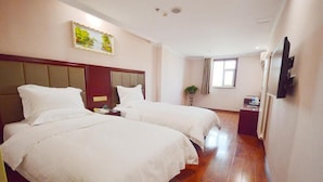 A hotel room with two beds, a wooden floor, a painting on the wall, and a TV mounted on the wall. - Greentree Inn Taizhou Taidong Hotel (Taizhou)