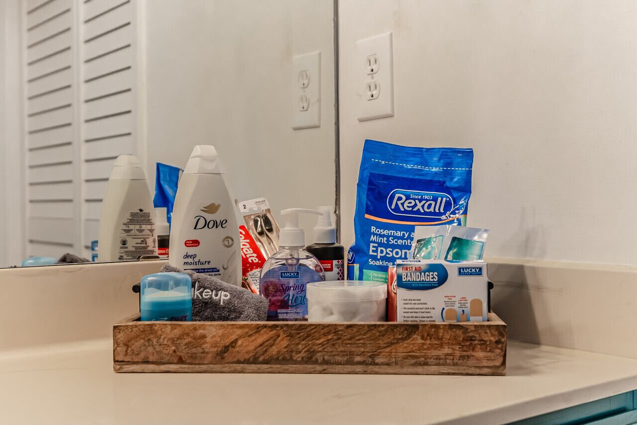 A bathroom counter with toiletries including Dove soap, Rexall Epsom salts, and a Keup bottle.