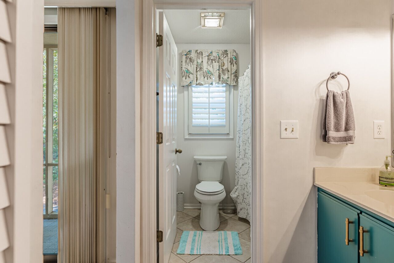 A bathroom with a toilet, a sink, and a towel rack.