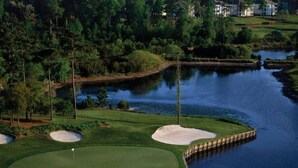 Un camp de golf amb búnquers, una zona d'aigua i un pont.