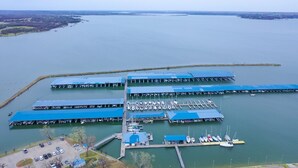 Un puerto deportivo con varios muelles y zonas cubiertas para embarcaciones.