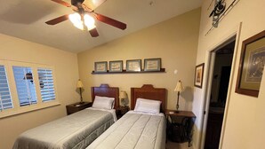 A bedroom with two beds, a ceiling fan, and framed pictures on the wall. - Sunset Getaway  (Welaka)