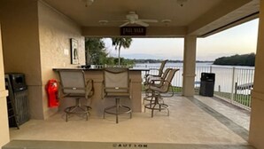 A covered outdoor area with a bar, two chairs, a fire extinguisher, and a caution sign. - Sunset Getaway  (Welaka)