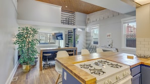 Een moderne keuken met een centraal eiland, een gasfornuis en een eethoek met stoelen.