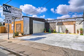 A commercial building with a speed limit sign of 35 mph, a storefront with 'SM MEXPORTS' signage, and a clear sky. - Ideally Located Vacation Rental Studio in Laredo! (Laredo)