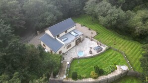 A two-story house with a large patio, a swimming pool, and a well-maintained lawn. - Rudbaxton Water (Haverfordwest)