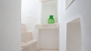 Un escalier étroit, avec une bouteille verte posée sur une étagère.