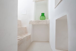 Eine schmale Treppe mit einer grünen Flasche auf einem Regal.