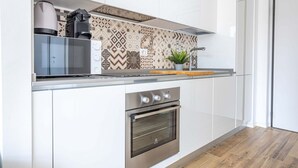 A modern kitchen with a built-in oven, microwave, and coffee maker. - Hostmate - Milano - Pirelli - Porta Nuova (Milano)