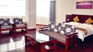 A hotel room with a bed, a sofa, a coffee table, and a chair. - Greentree Inn Xuzhou Benteng Avenue Express Hotel (Xuzhou)