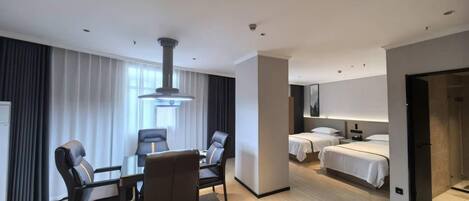 A hotel room with a dining area, two beds, a large window, and a modern design.