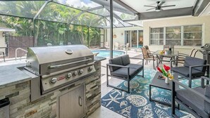 A covered outdoor area with a grill, pool, and seating. - The Edison - Walking Distance to Gulf Course and Edison-Ford Winter Home (Fort Myers)