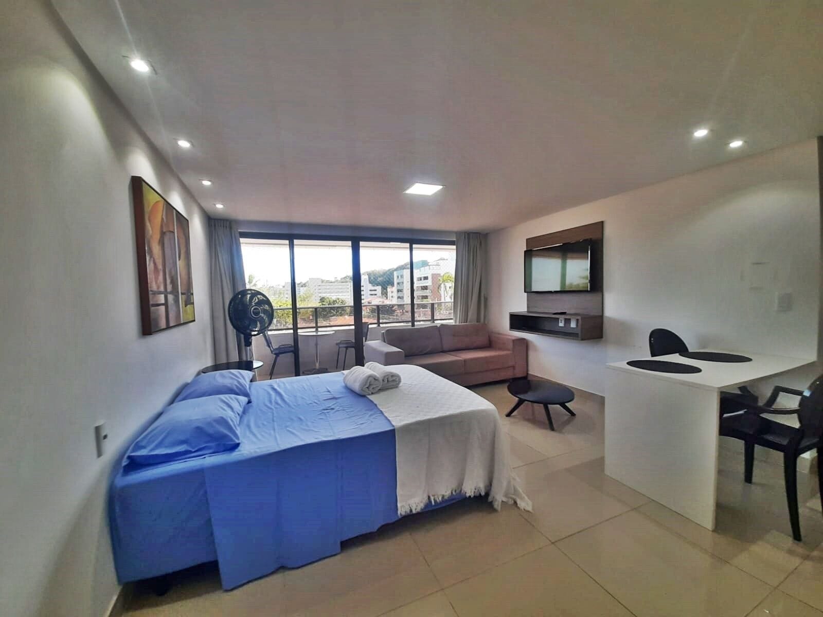 Une chambre d’hôtel moderne équipée d’un lit, d’un canapé, d’un bureau et d’une télévision.