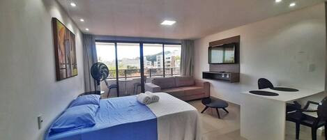 Une chambre d’hôtel moderne équipée d’un lit, d’un canapé, d’un bureau et d’une télévision.