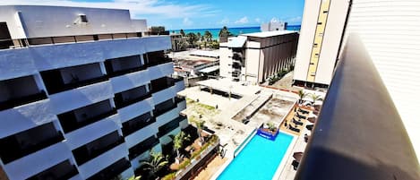 Ein Hochhaus mit Pool auf dem Dach und Blick auf den Ozean.