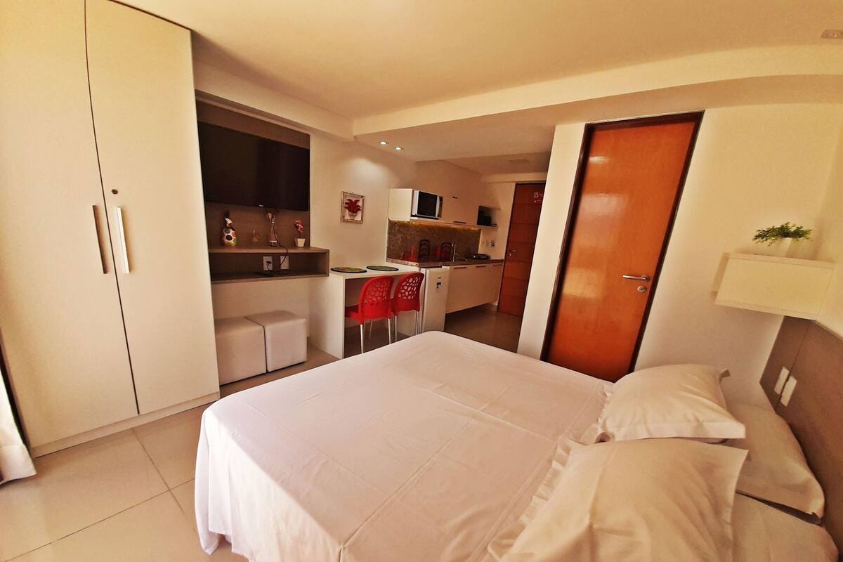 Un dormitorio con cama, kitchenette y baño.
