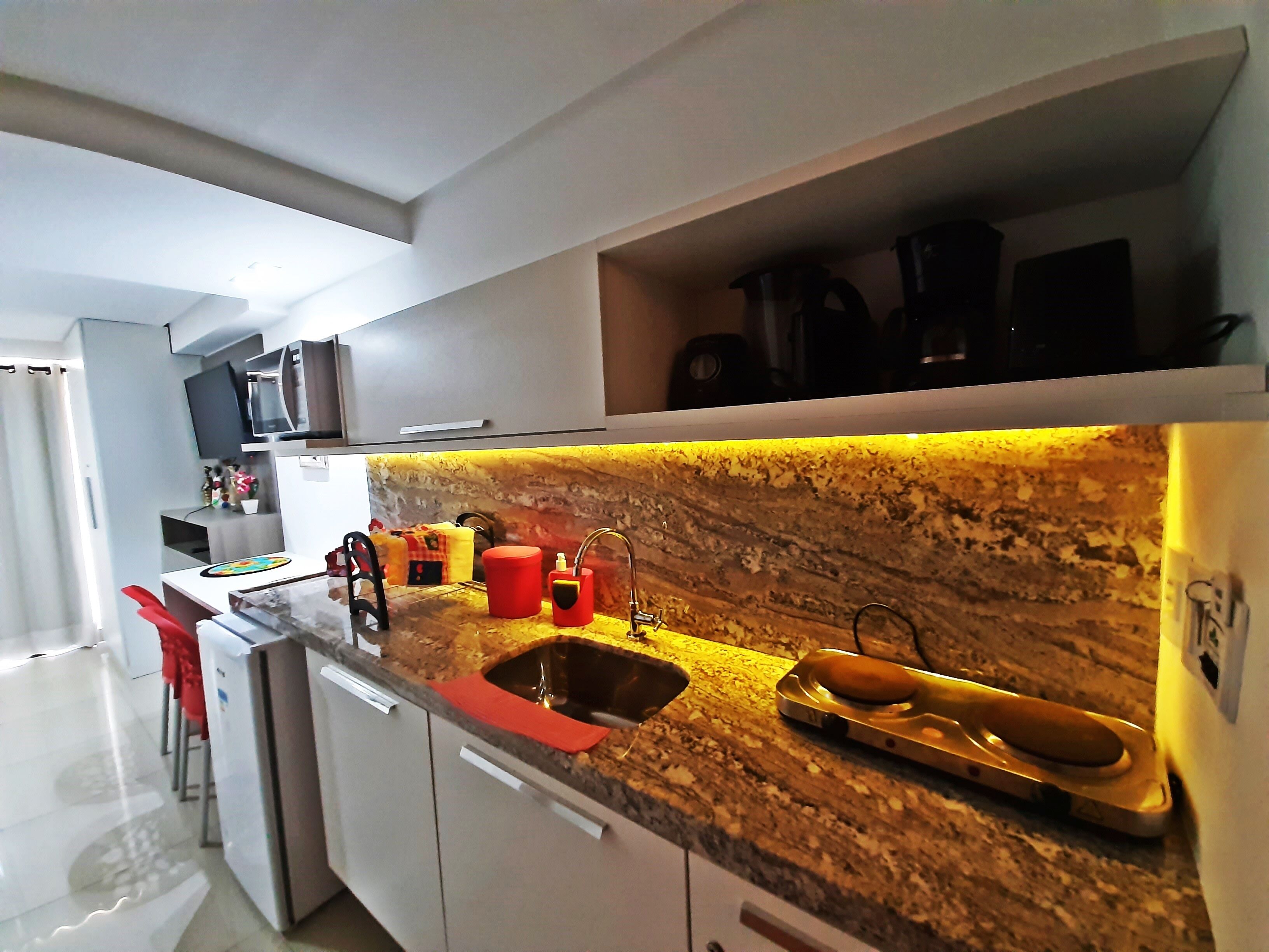 A modern kitchen with a granite countertop, stainless steel sink, and a built-in oven.