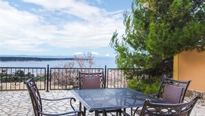 A patio with a table and chairs overlooking a body of water. - 3 bedroom awesome apartment in Rab (Rab)