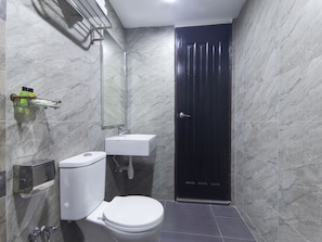 A bathroom with a toilet, sink, and a dark door. - Hotel Midaris Syariah Kuala Lumpur (Kuala Lumpur)