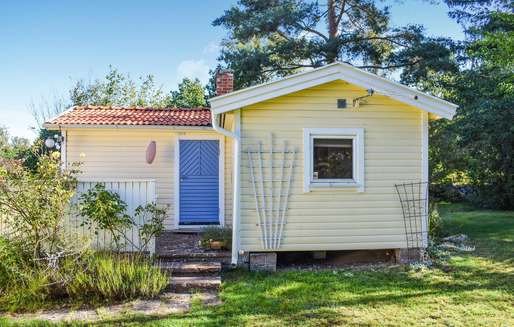 A small yellow house with a blue door and a white window.