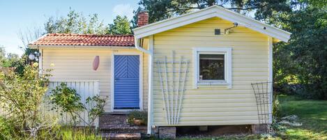 A small yellow house with a blue door and a white window.