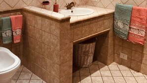 A bathroom with a sink, mirror, and toilet. - The Attichetto (Ciampino)