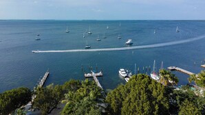 Un puerto deportivo con varias embarcaciones amarradas, rodeado de abundante vegetación y un cielo despejado.
