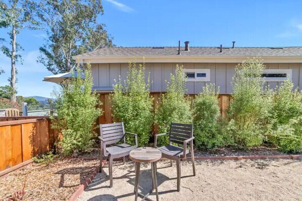 A house with a covered patio area featuring two chairs and a small table. - 4BR/2.5BA Home 3 Blocks to Beach (Half Moon Bay)