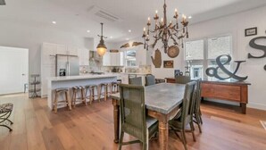 A spacious kitchen with white cabinets, a large island, and a chandelier. - Updated and Spacious 3BR/2BA Victorian Style Home (Petaluma)