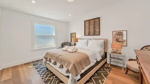 A bedroom with a bed, bedside table, chair, and a window. - Updated and Spacious 3BR/2BA Victorian Style Home (Petaluma)