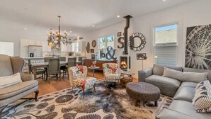 A modern living room with a fireplace, a dining area, and a large window. - Updated and Spacious 3BR/2BA Victorian Style Home (Petaluma)